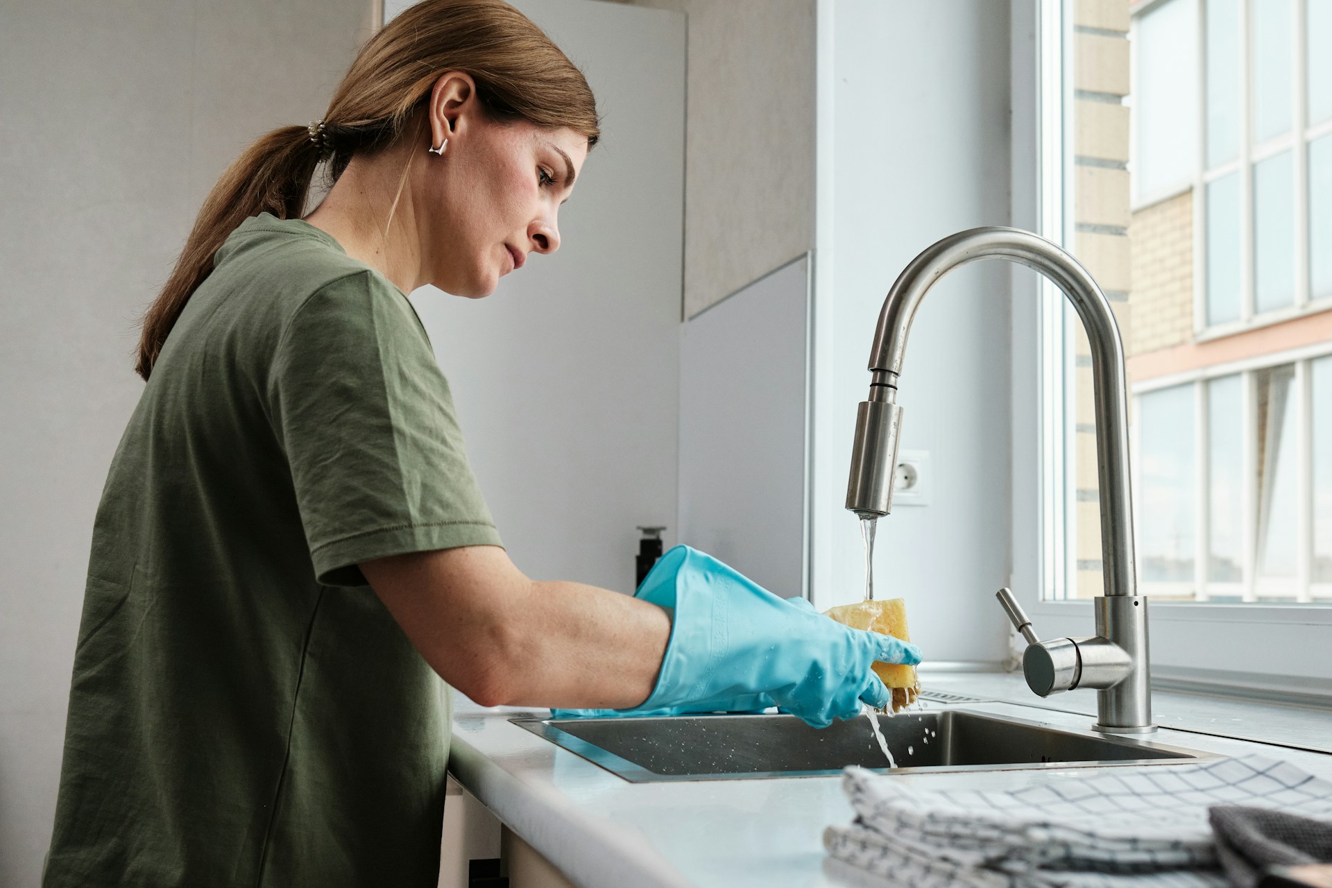 woman washing dishes in the kitchen sink